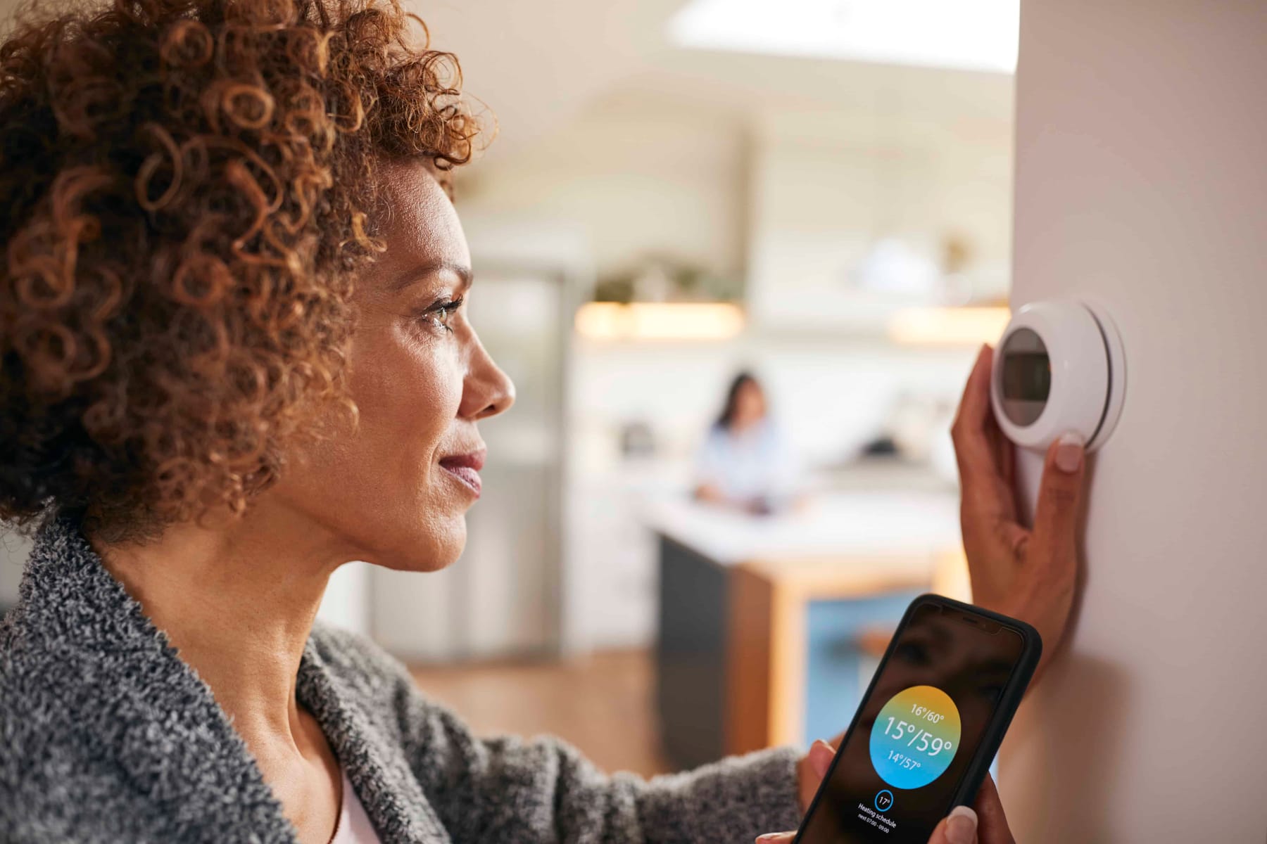 Mature woman using app on phone to control